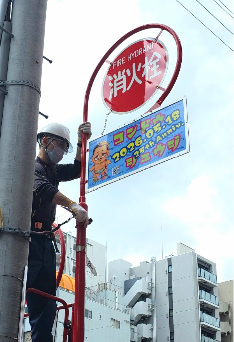 消火栓標識に近藤修司選手の応援看板を取り付ける設置作業の様子